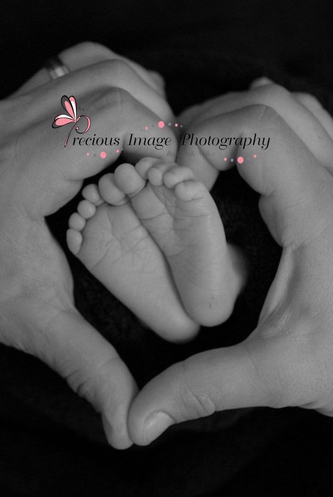 newborn baby feet with dads hand in a heart