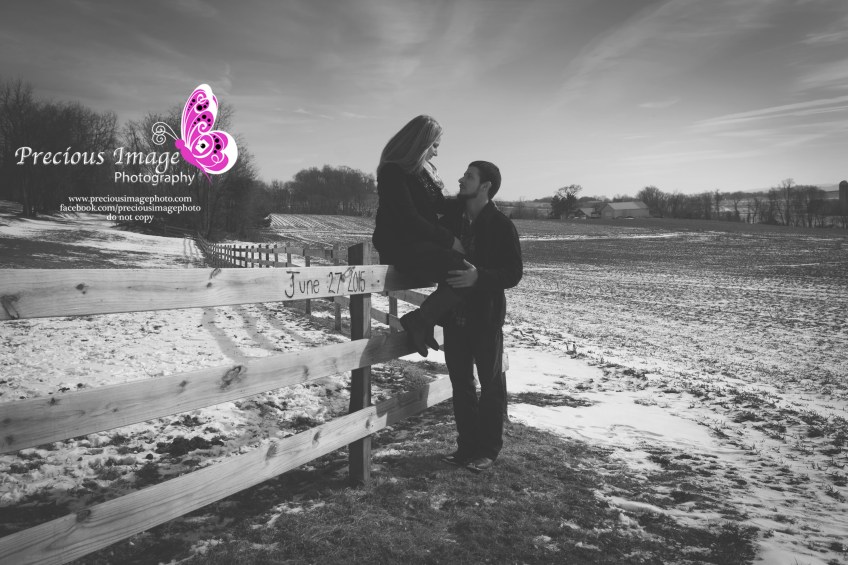 engagement couple sitting on the fence with a beautiful sky background