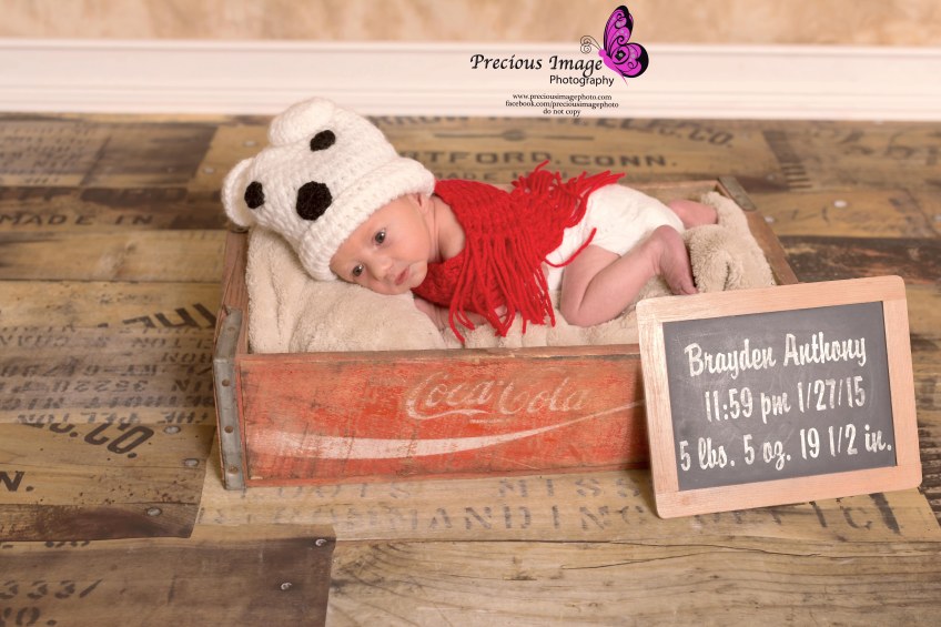 newborn with chalkboard wearing polar bear outfit in coke cola box